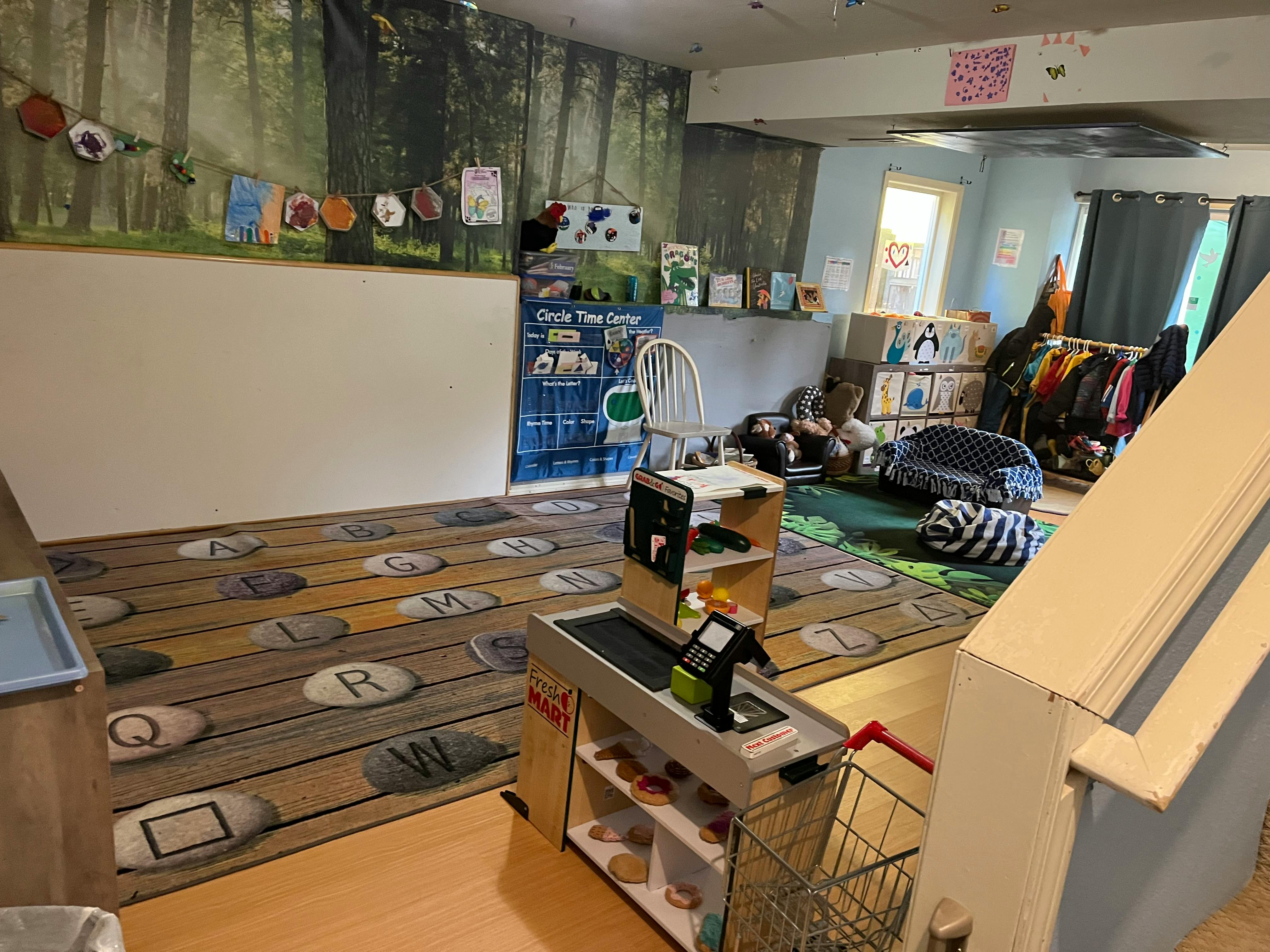 Playroom with a rug featuring letters and a toy checkout counter