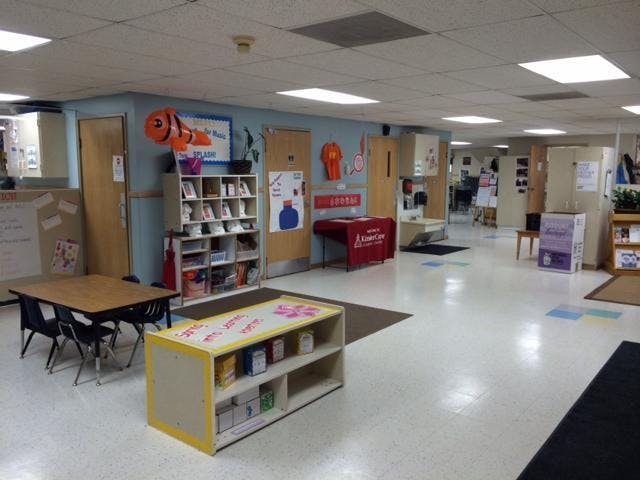 Classroom or daycare with tables, chairs, shelving, and decorations
