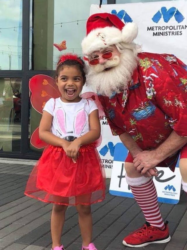 Child in fairy costume with person dressed as Santa Claus
