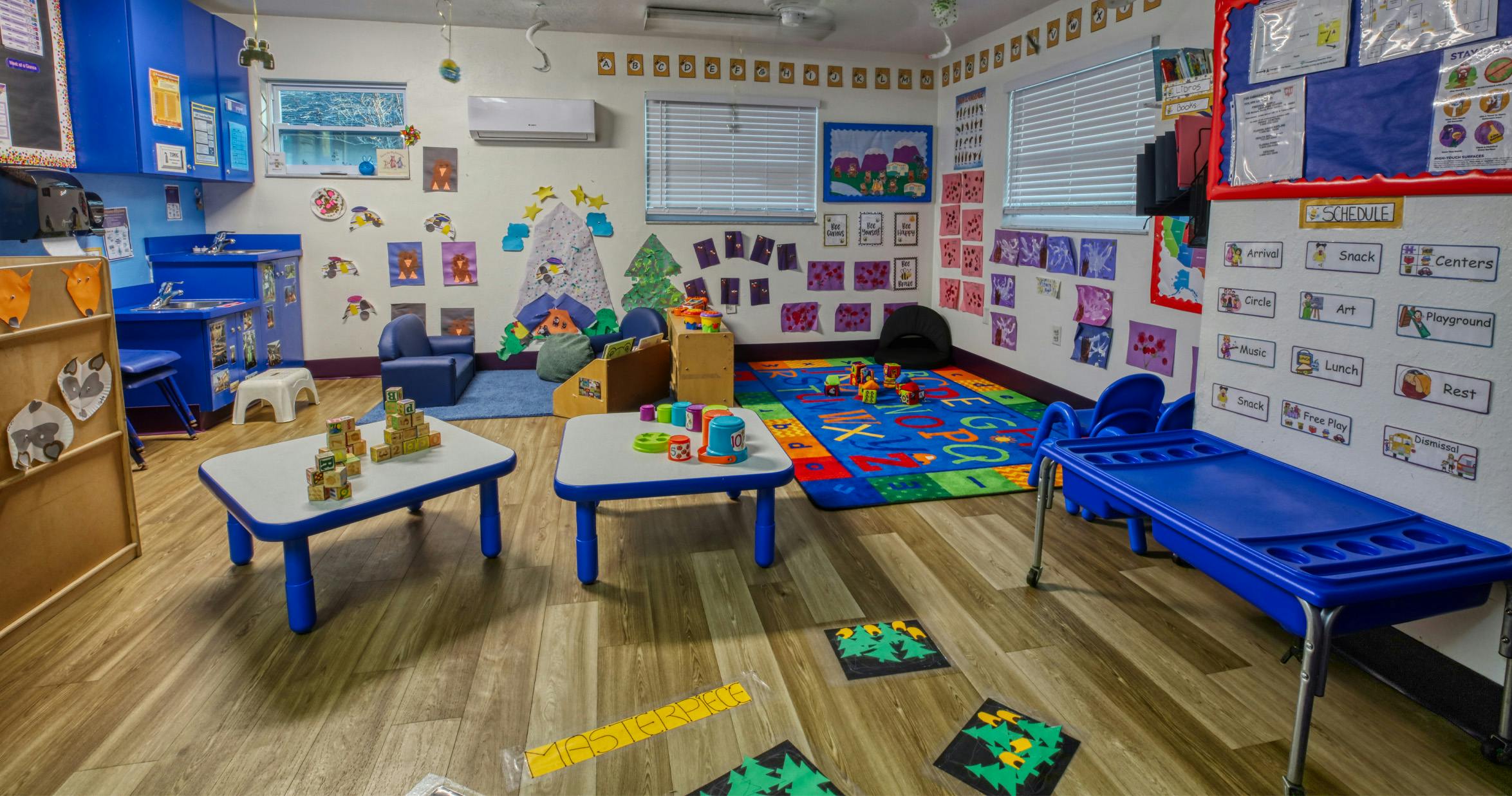 A colorful classroom with small tables, chairs, and learning materials