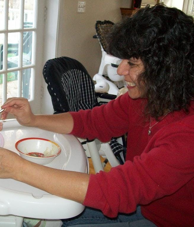 Person feeding a child in a high chair