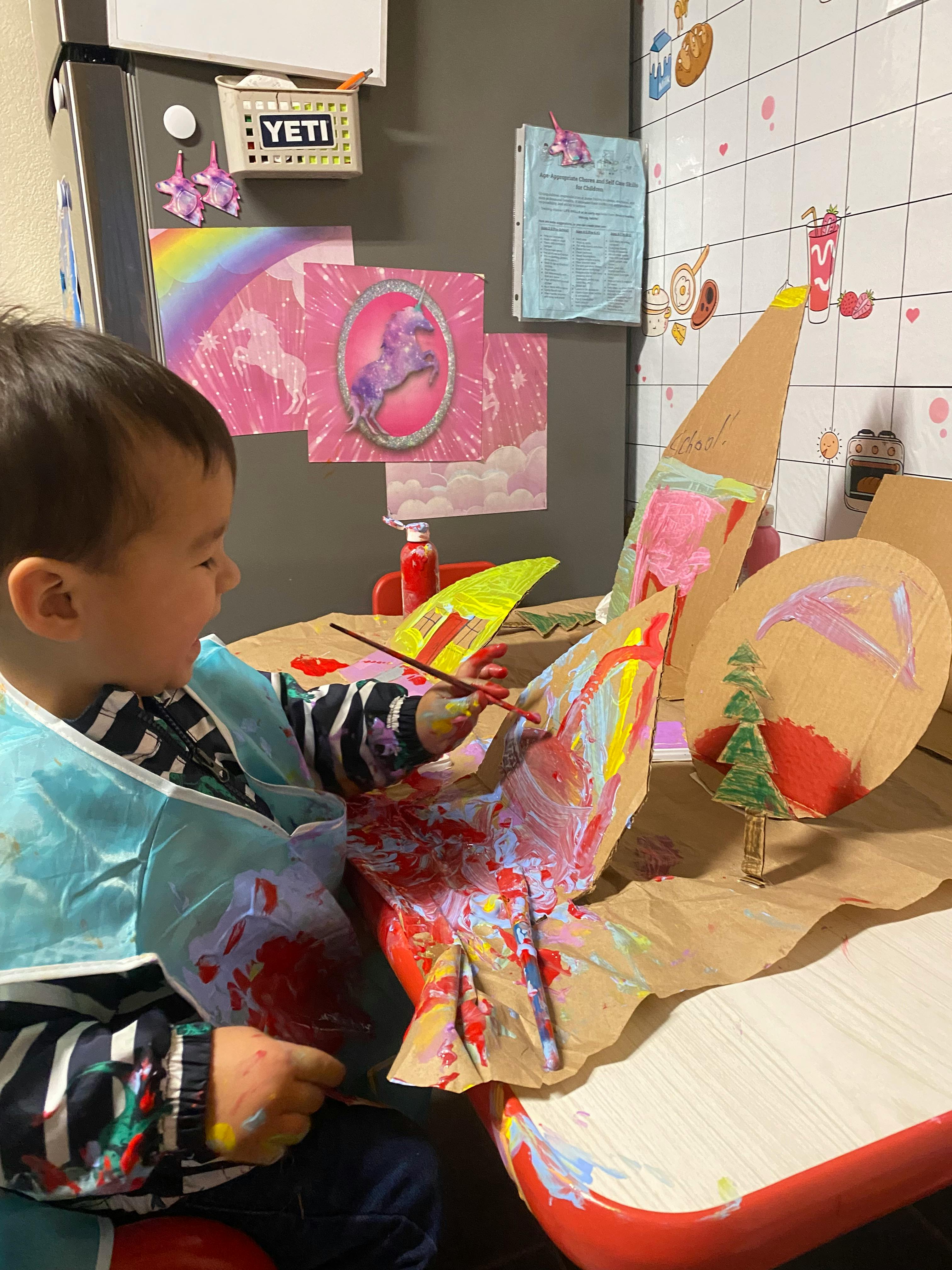 Child painting a cardboard craft project