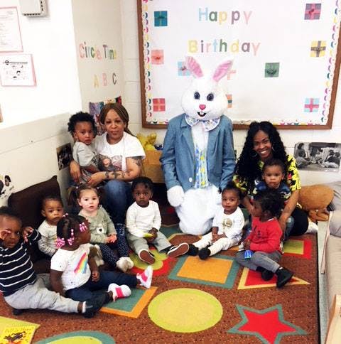 Adults and children posing with a person in a bunny costume