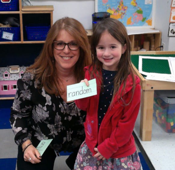 Person and child holding a card with the word "random"
