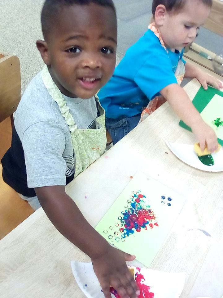 Two children painting at a table