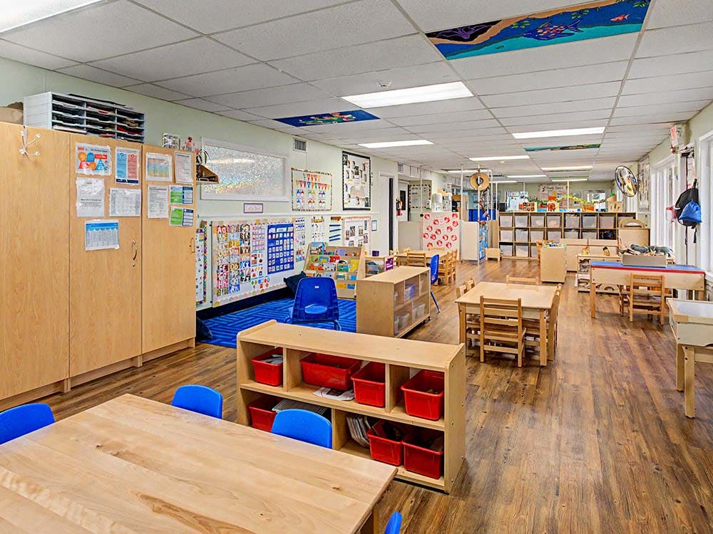 An empty classroom with small tables and chairs