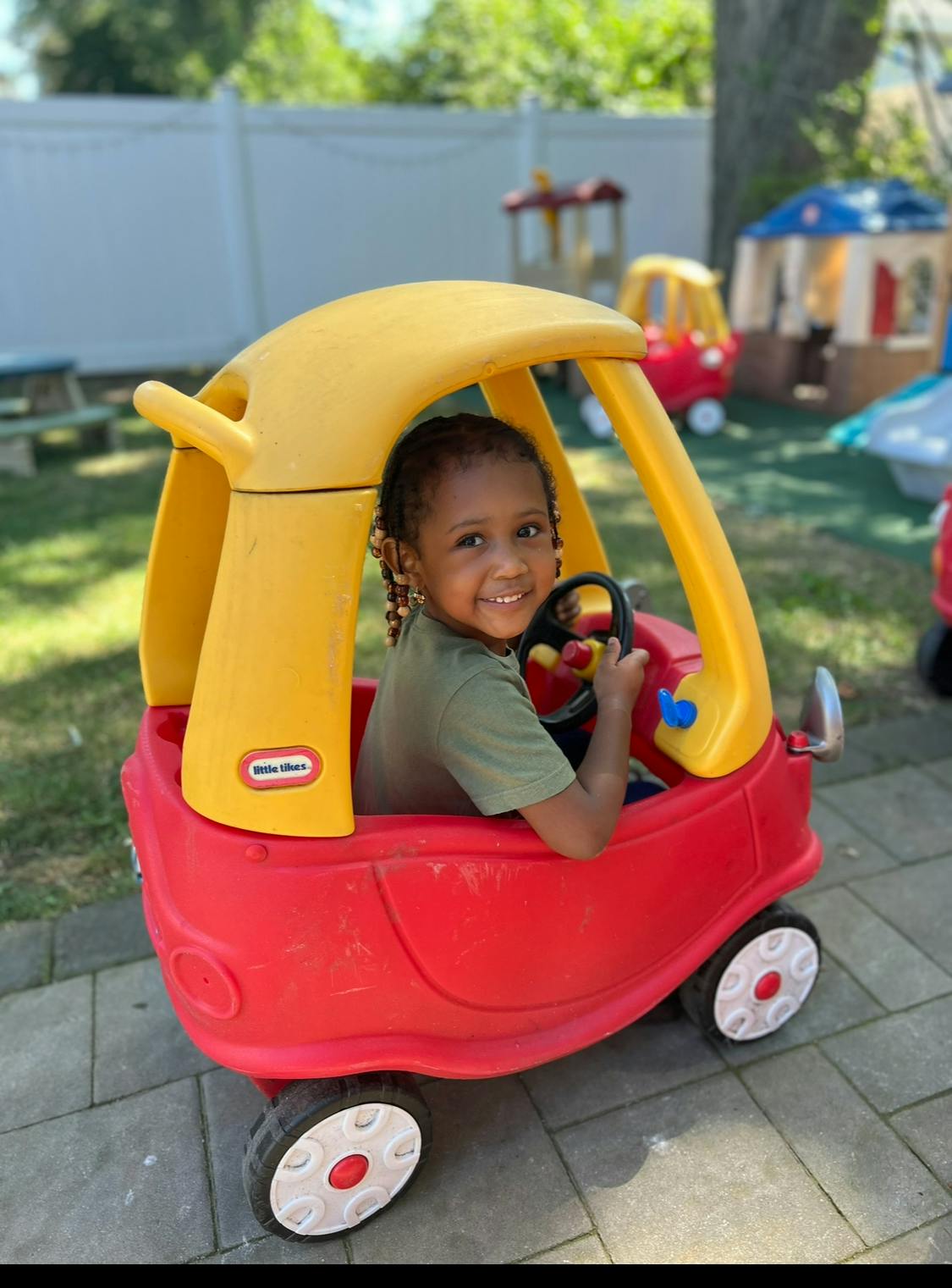 Child in a red and yellow toy car