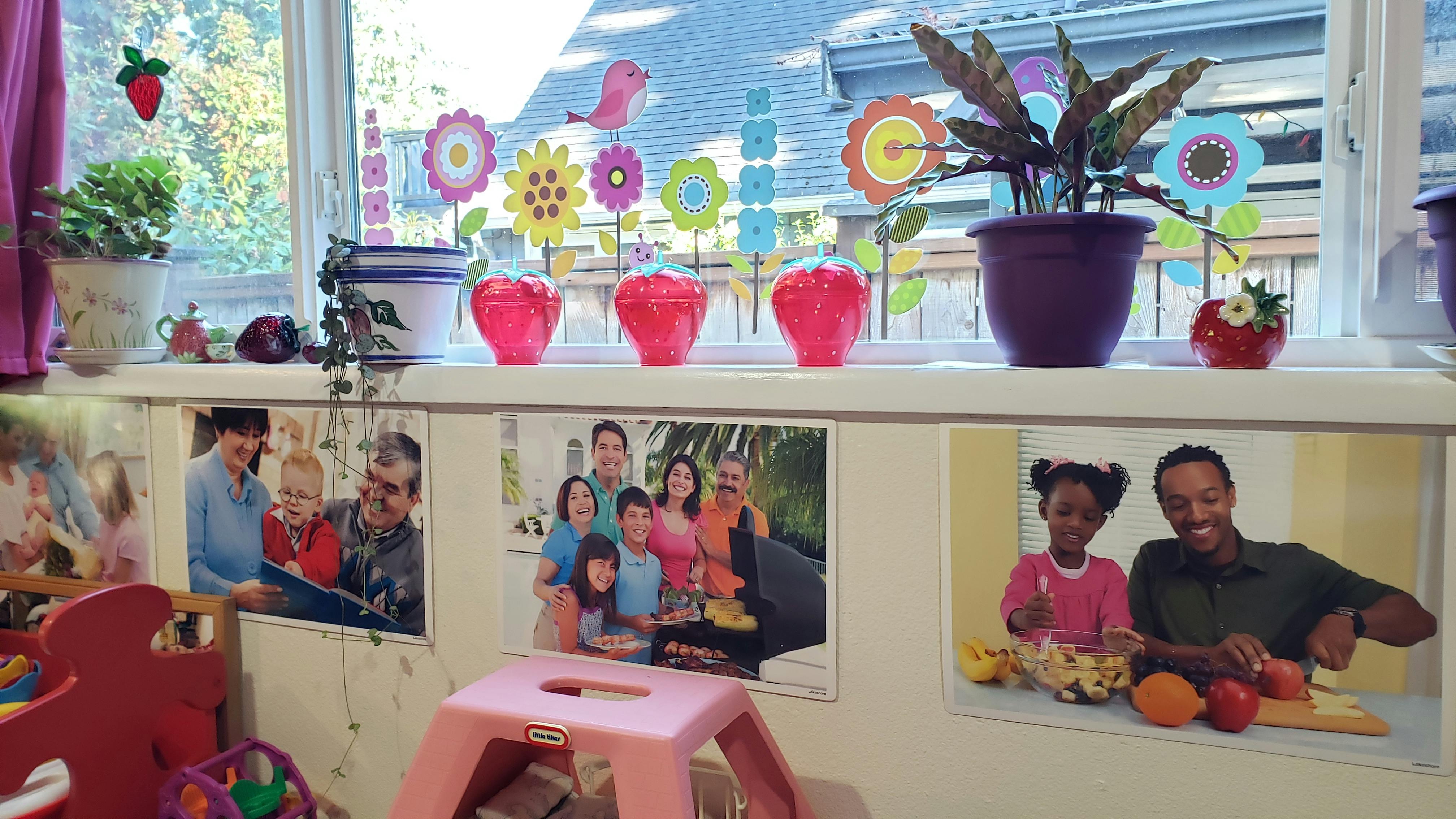 Window with plants and decorations above photos of people