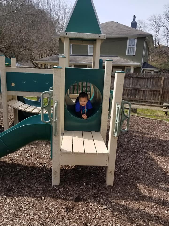Child looking out from a tunnel on a playground