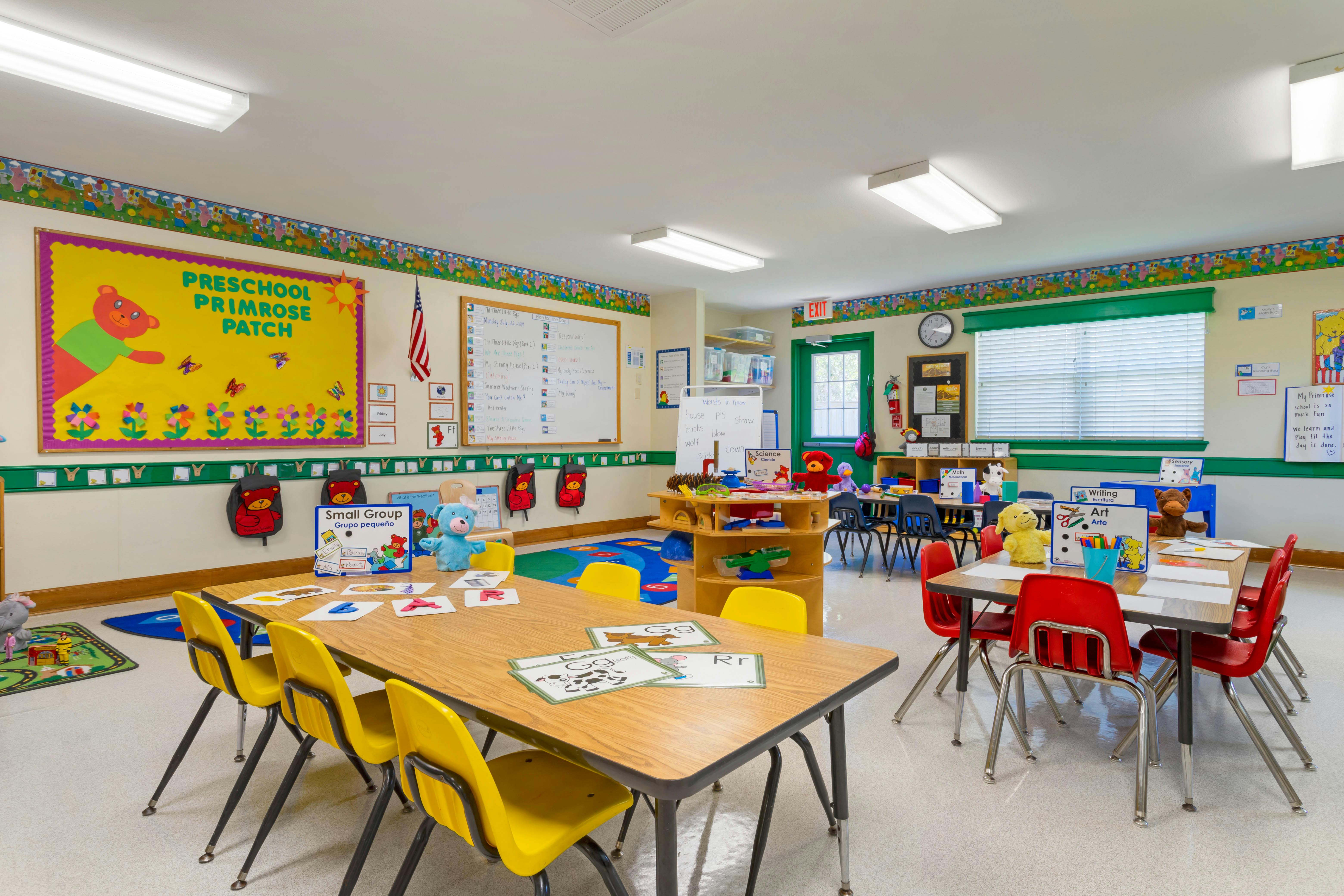 A colorful preschool classroom with tables, chairs, and learning materials
