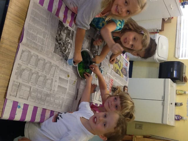 Children gathered around a table covered with newspaper