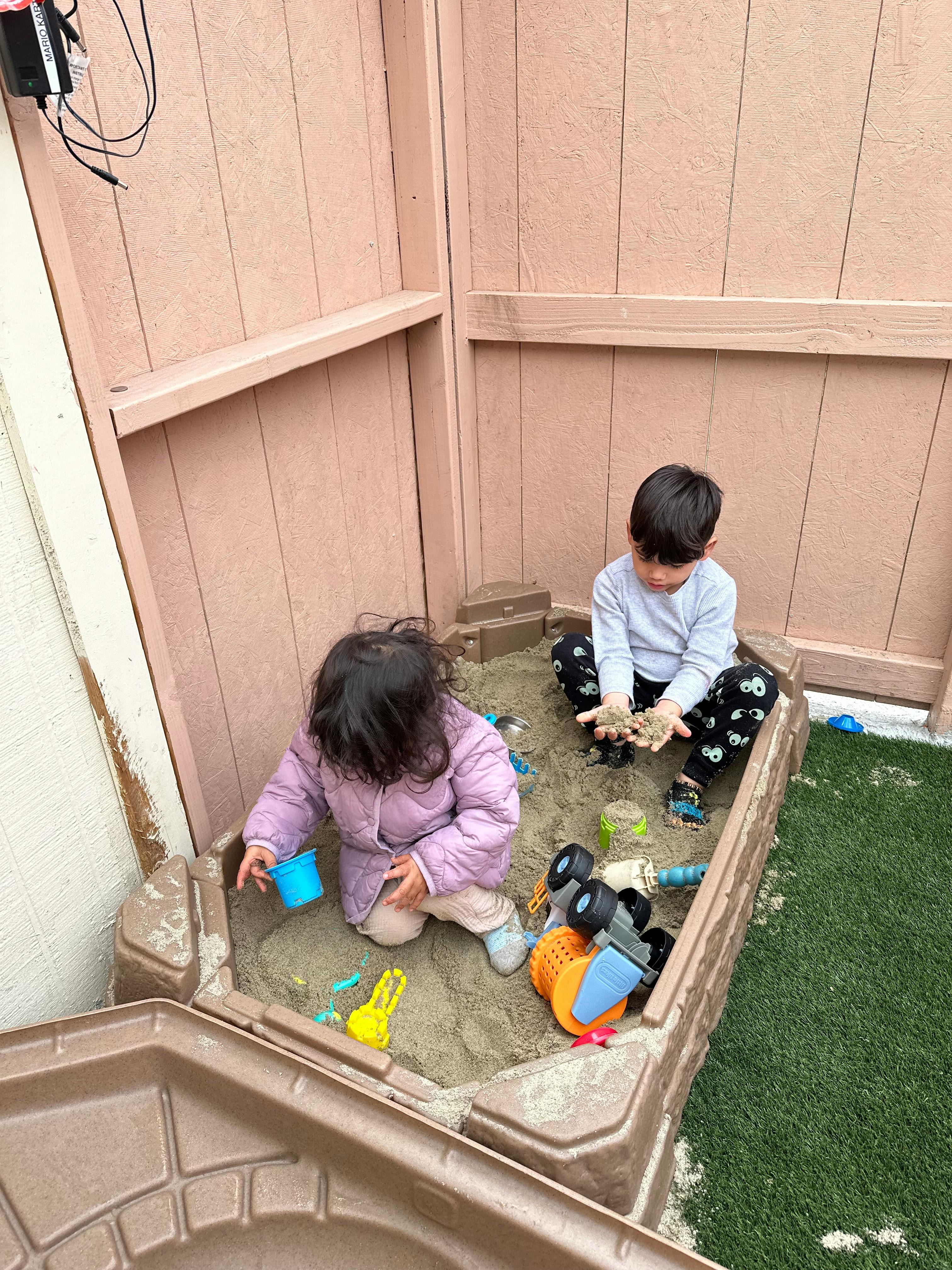 Two children playing in a sandbox