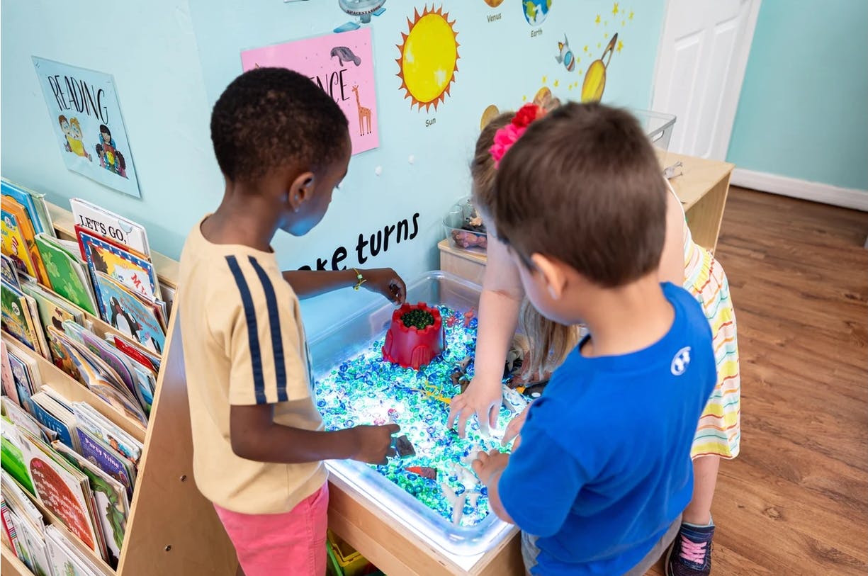 Children playing at a light table with translucent objects