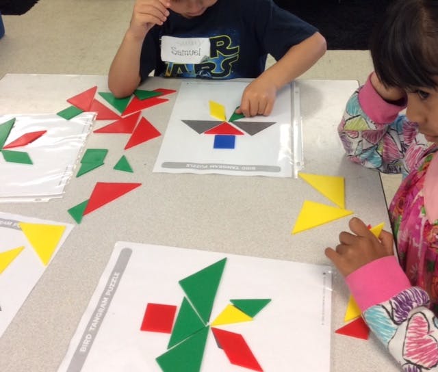 Children playing with colorful geometric shapes on a table
