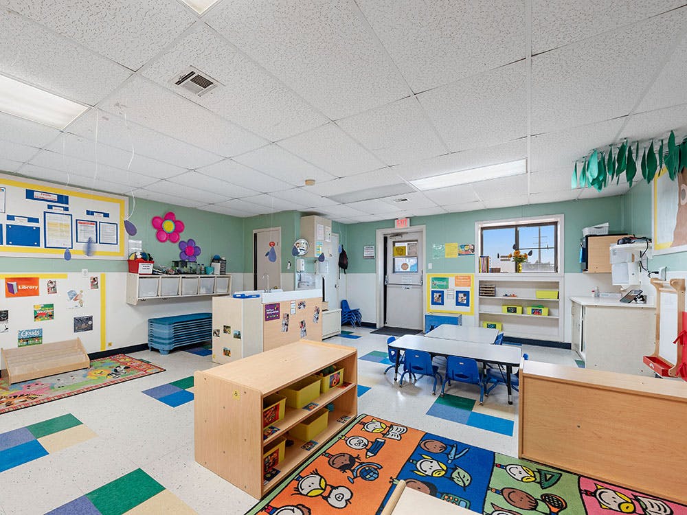 An empty colorful classroom with small tables and chairs