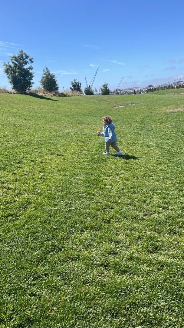Child running across a grassy field