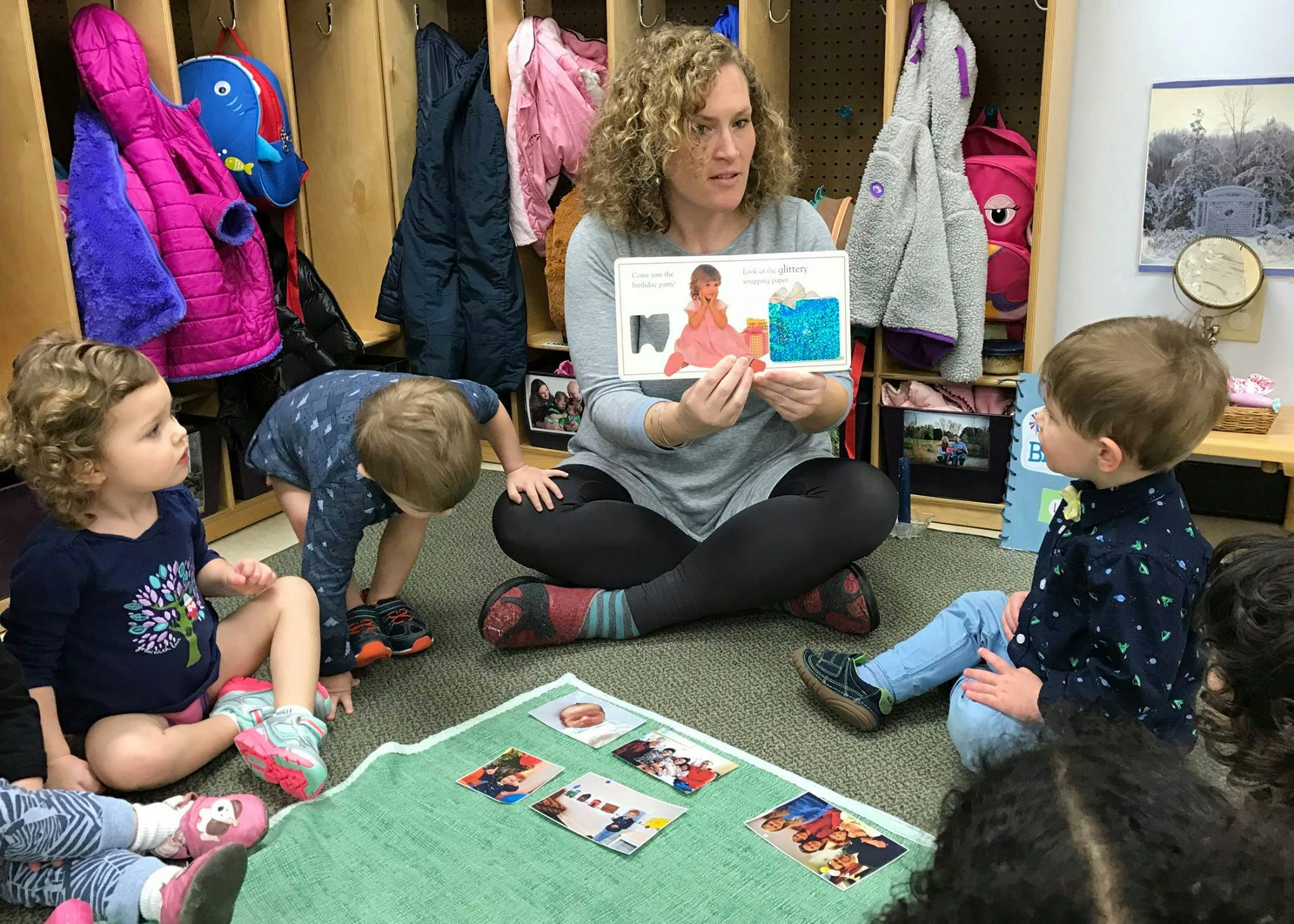 Person reading a book to children in a classroom