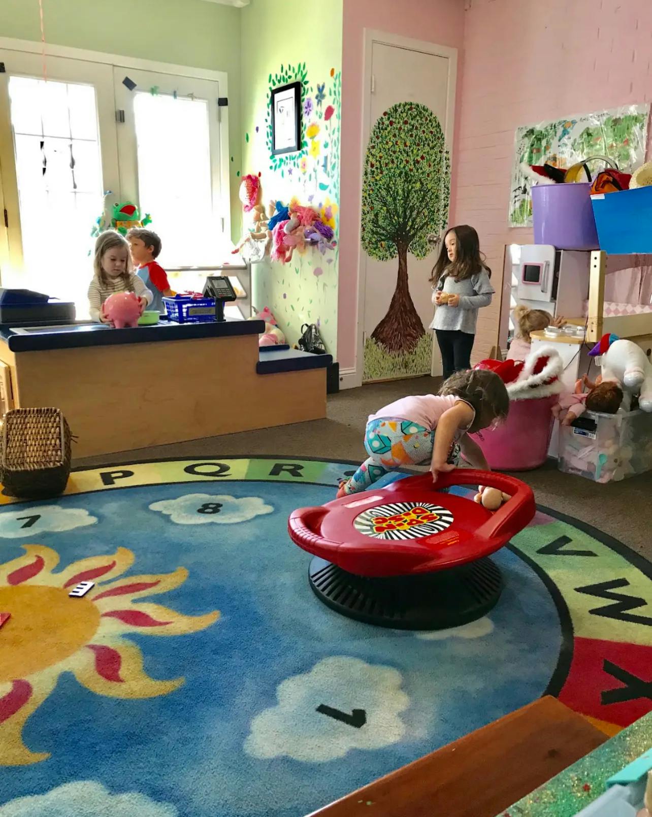 Children playing in a room with a sun and cloud rug