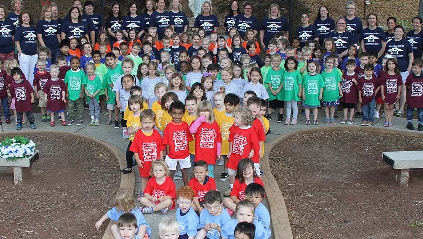 Large group of adults and children posing outdoors