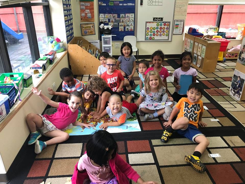 Group of children sitting on a rug in a classroom