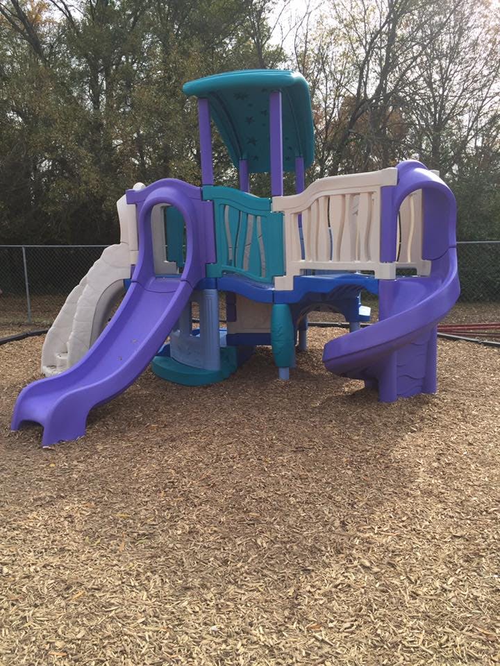 Playground structure with slides and platforms on wood chips