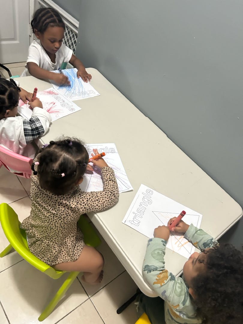 Children coloring at a table in a classroom