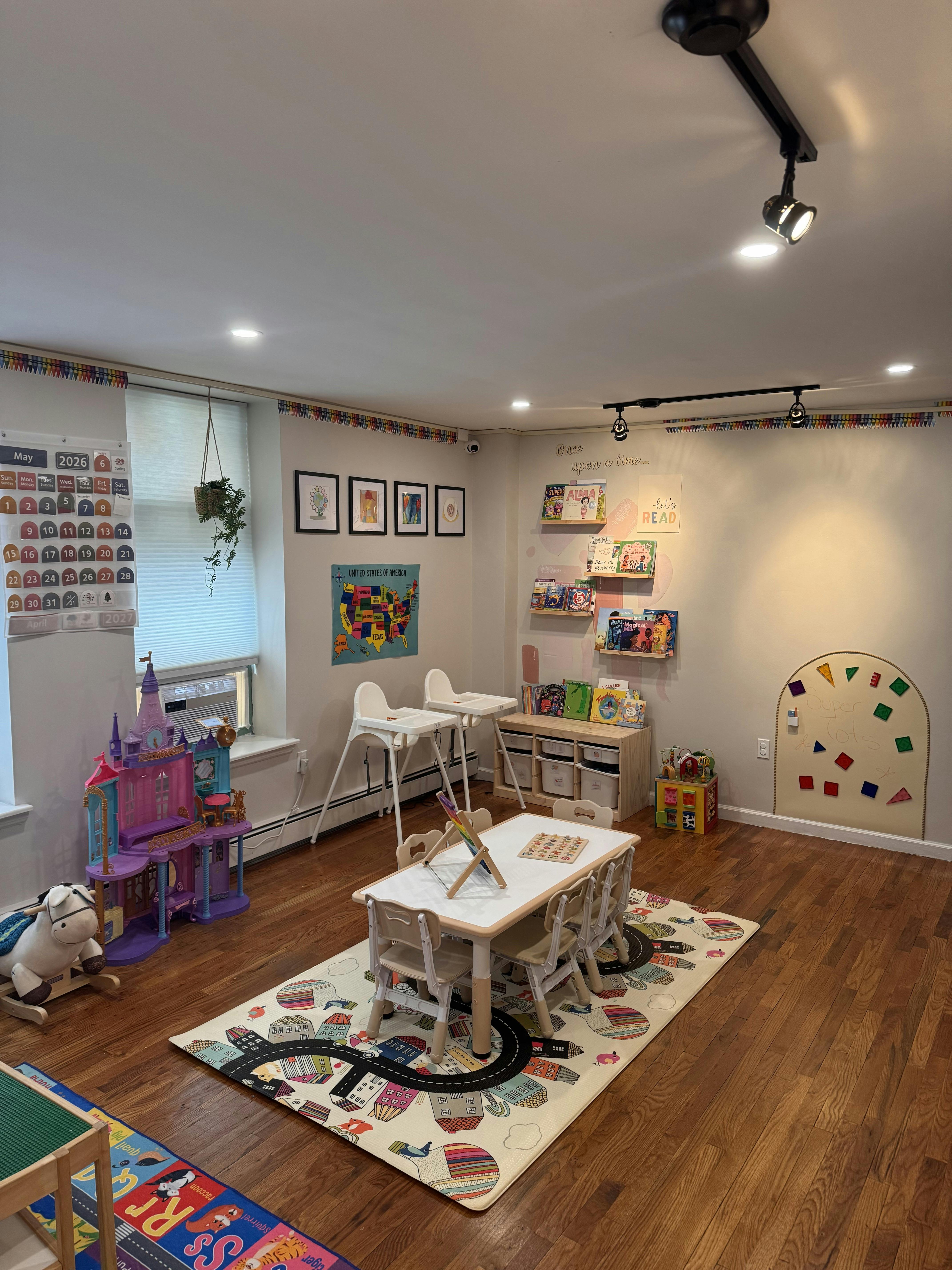 Children's playroom with a small table, chairs, toy castle, and book shelves