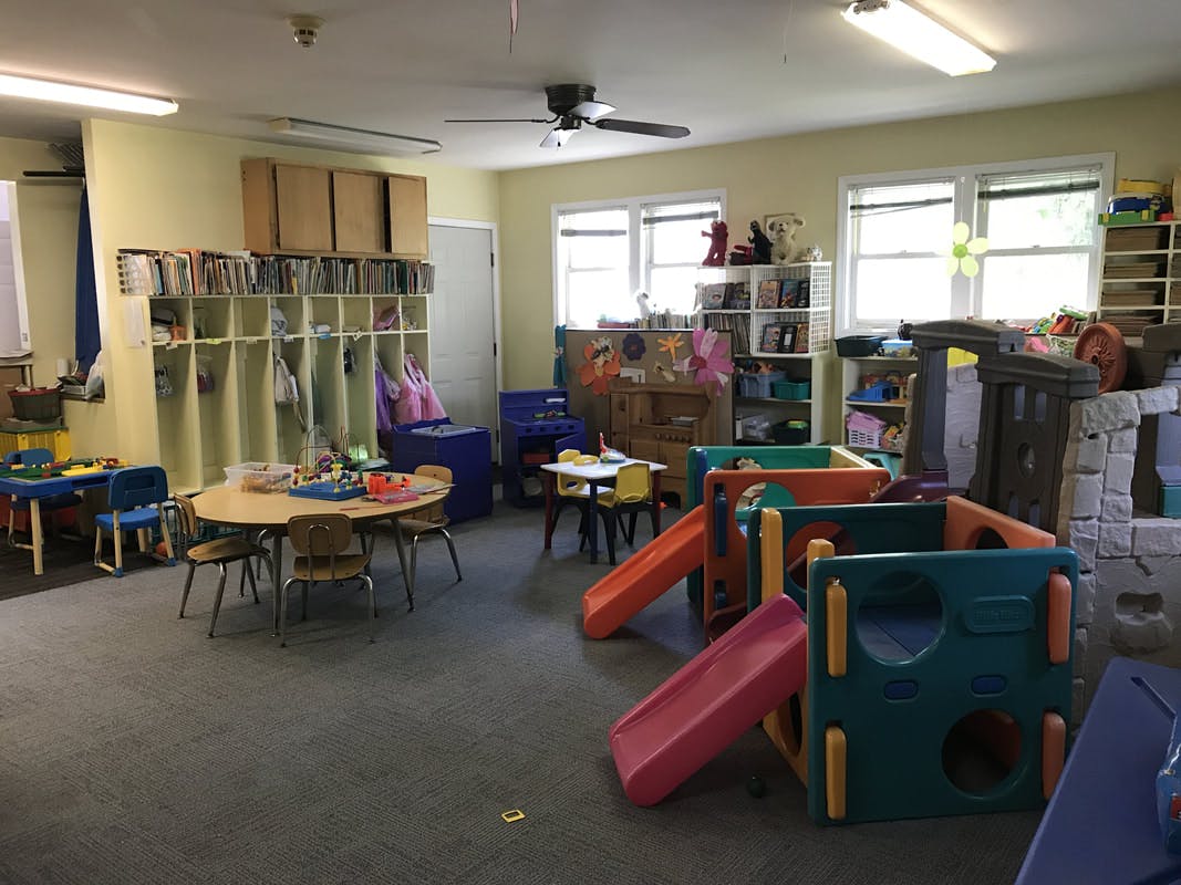 Indoor play area with slides, tables, and cubbies