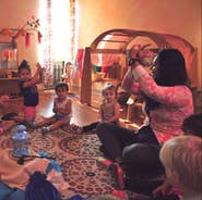 Adult and children sitting on a rug