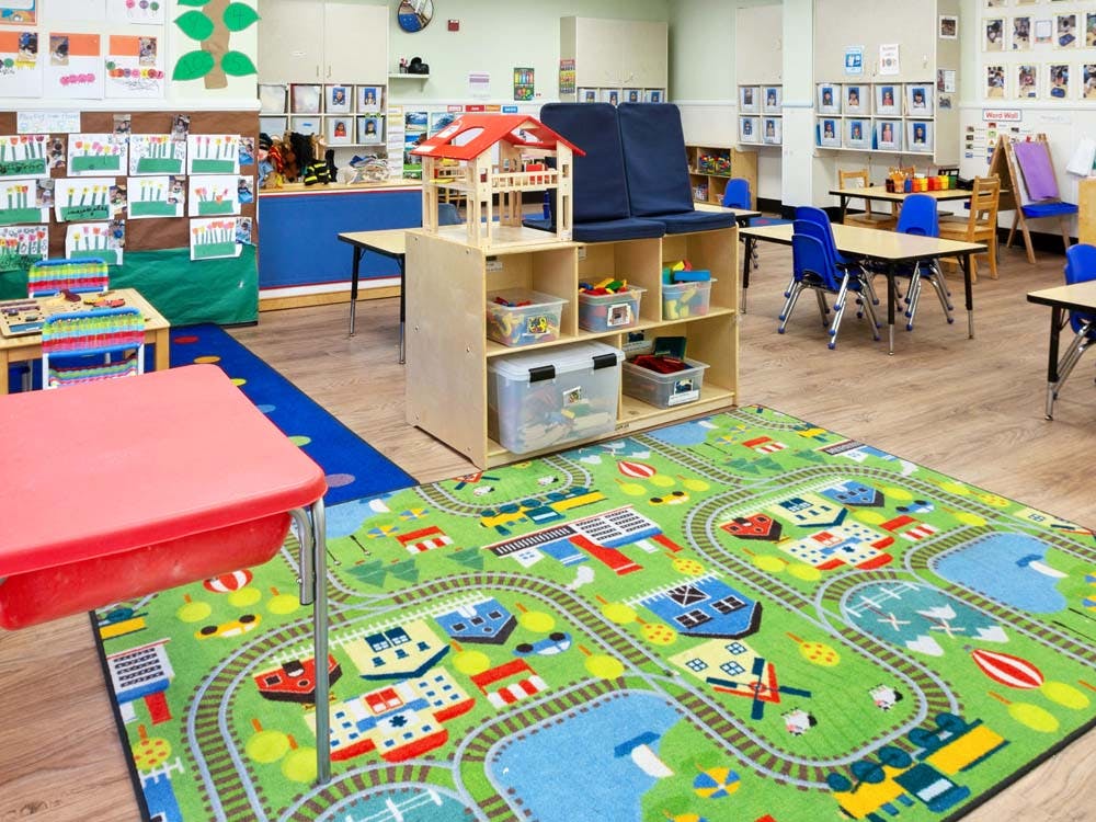 An empty early childhood classroom with a train track rug