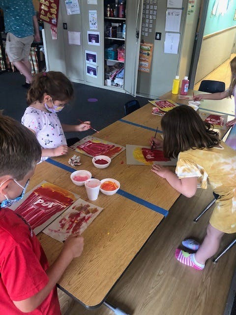 Three children painting at a table