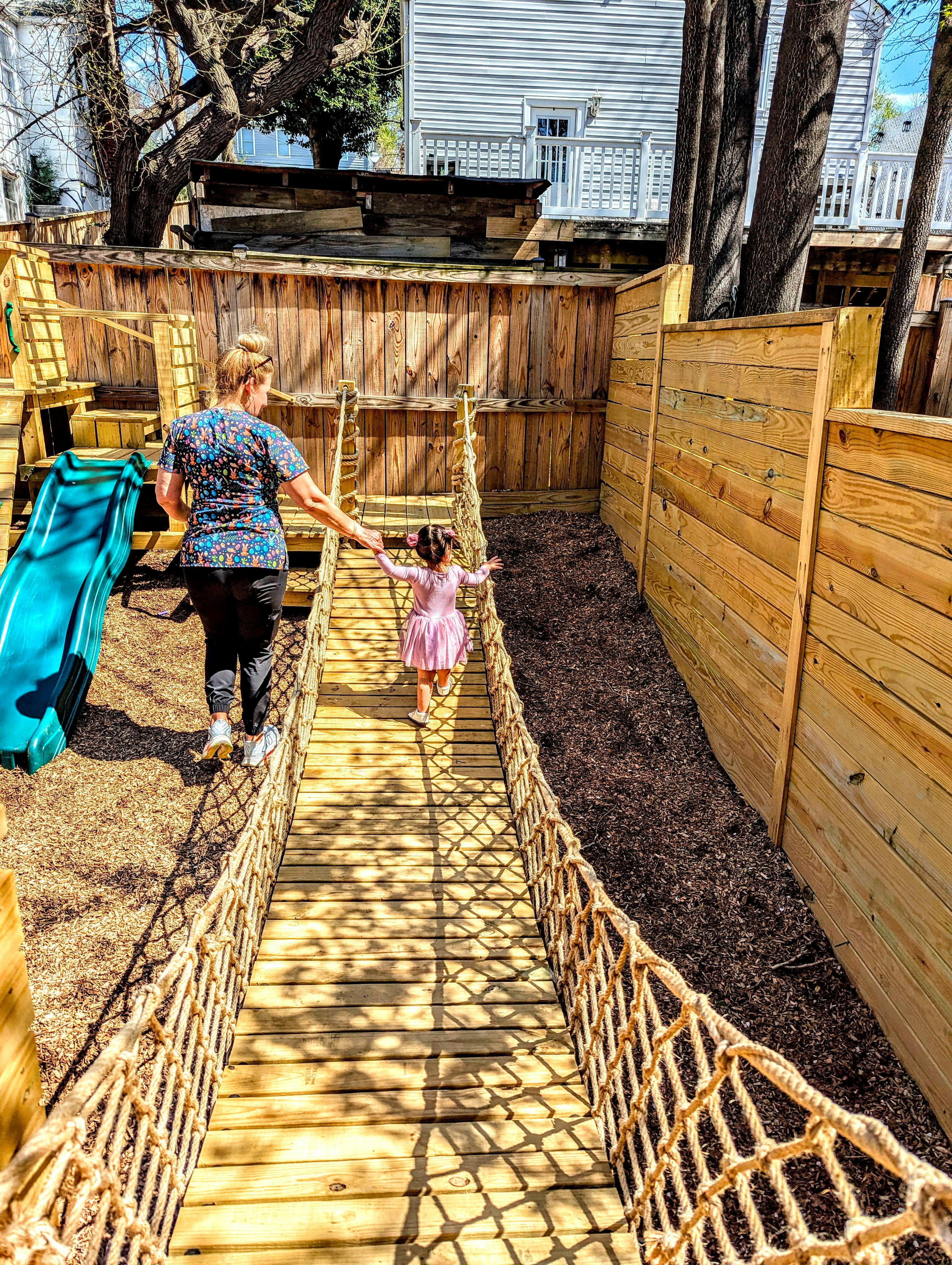 Person and child walking on a rope bridge
