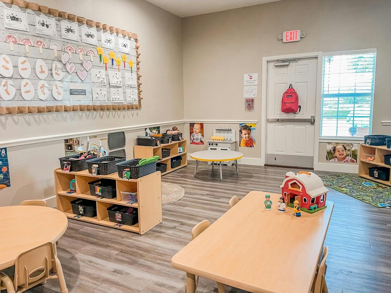 Classroom interior with small tables, shelves, and educational decorations