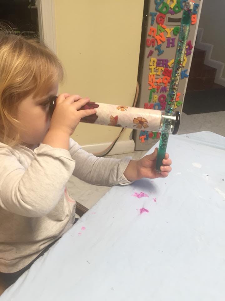 Child looking through a kaleidoscope