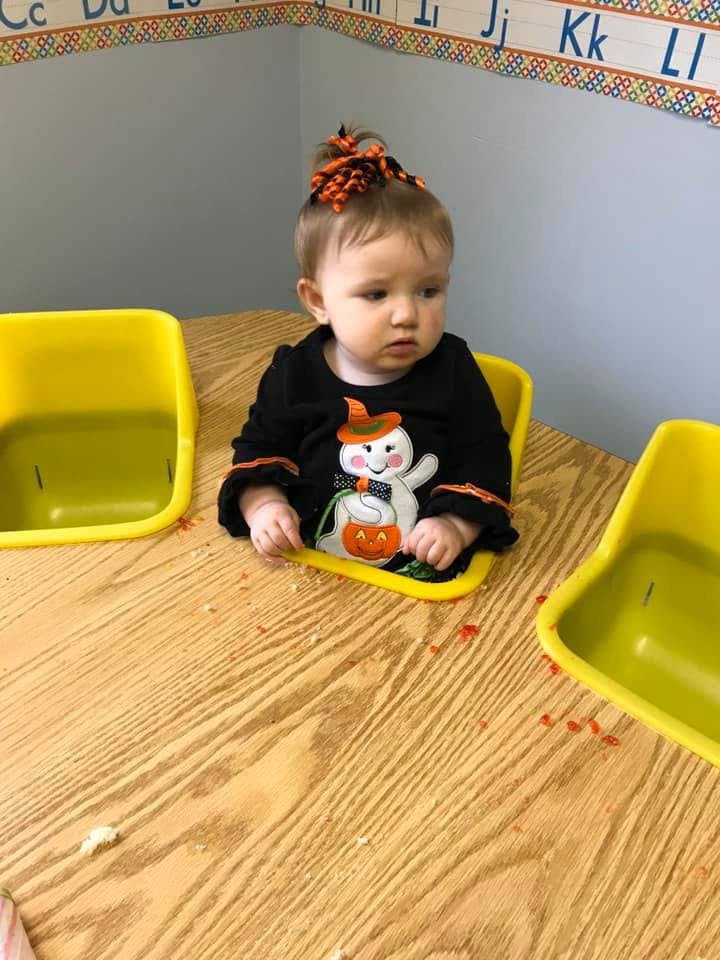 Child in a black shirt with a ghost design sitting at a table