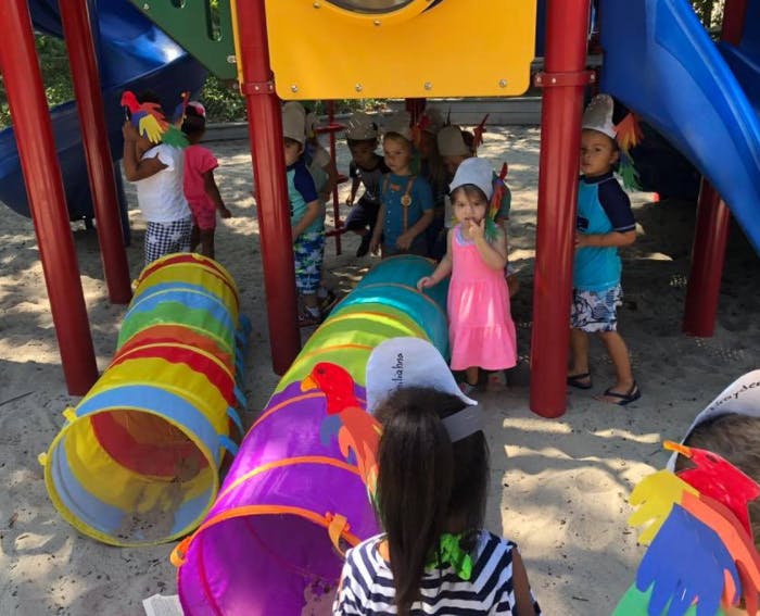 Children playing on a playground with colorful tunnels