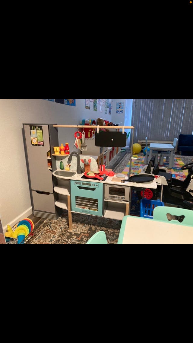Child's play kitchen with a refrigerator, sink, and stove