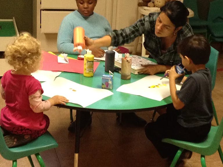 Adults and children doing crafts at a table