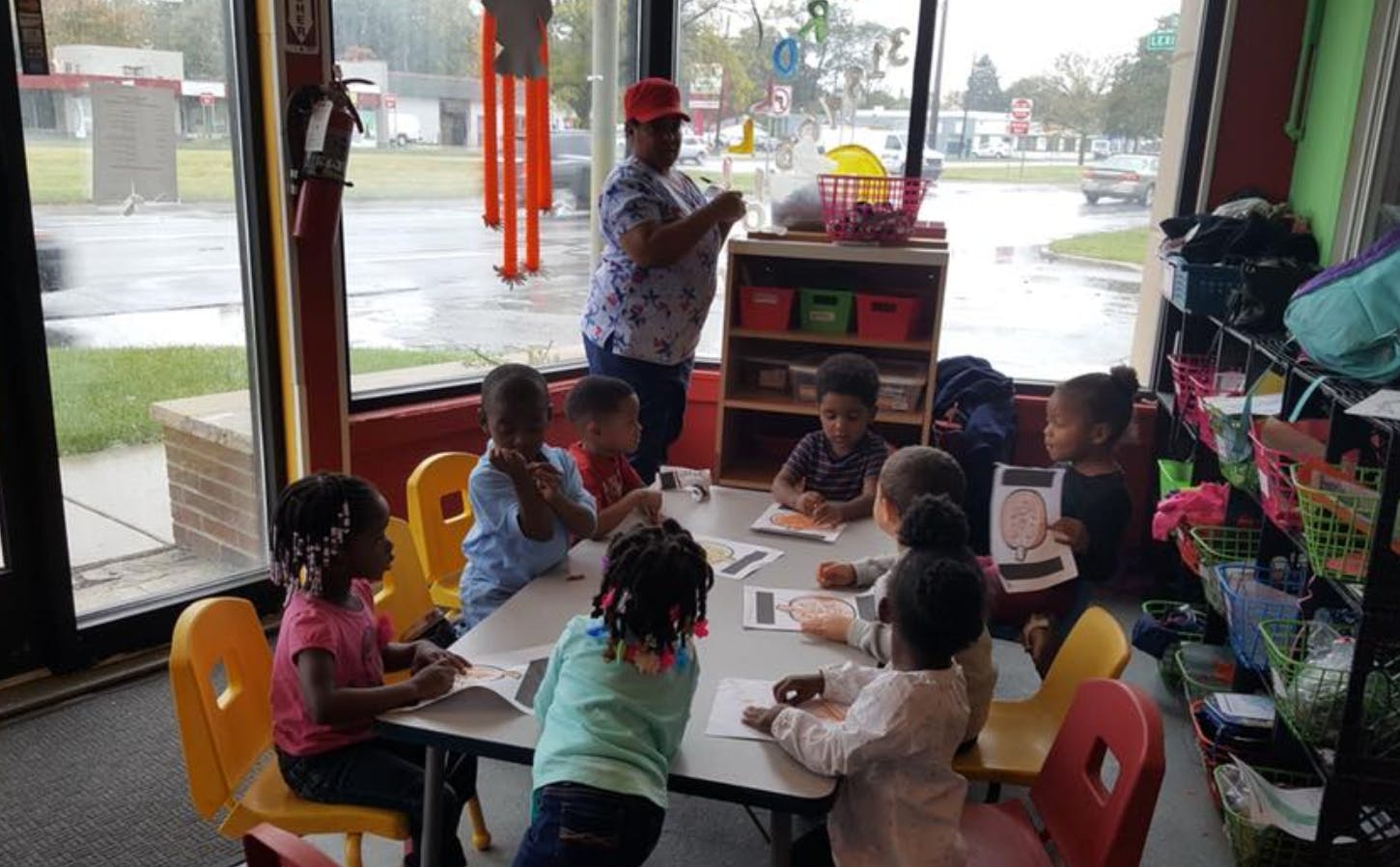 Adult and multiple children seated at a table in a classroom