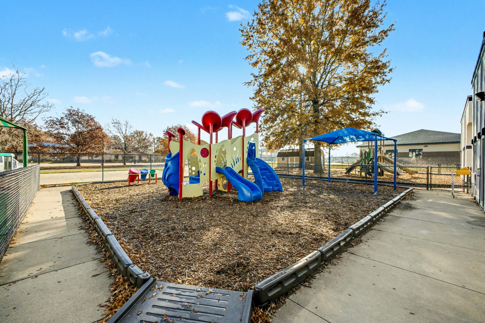 Colorful playground with multiple slides and a climbing structure under a blue sky