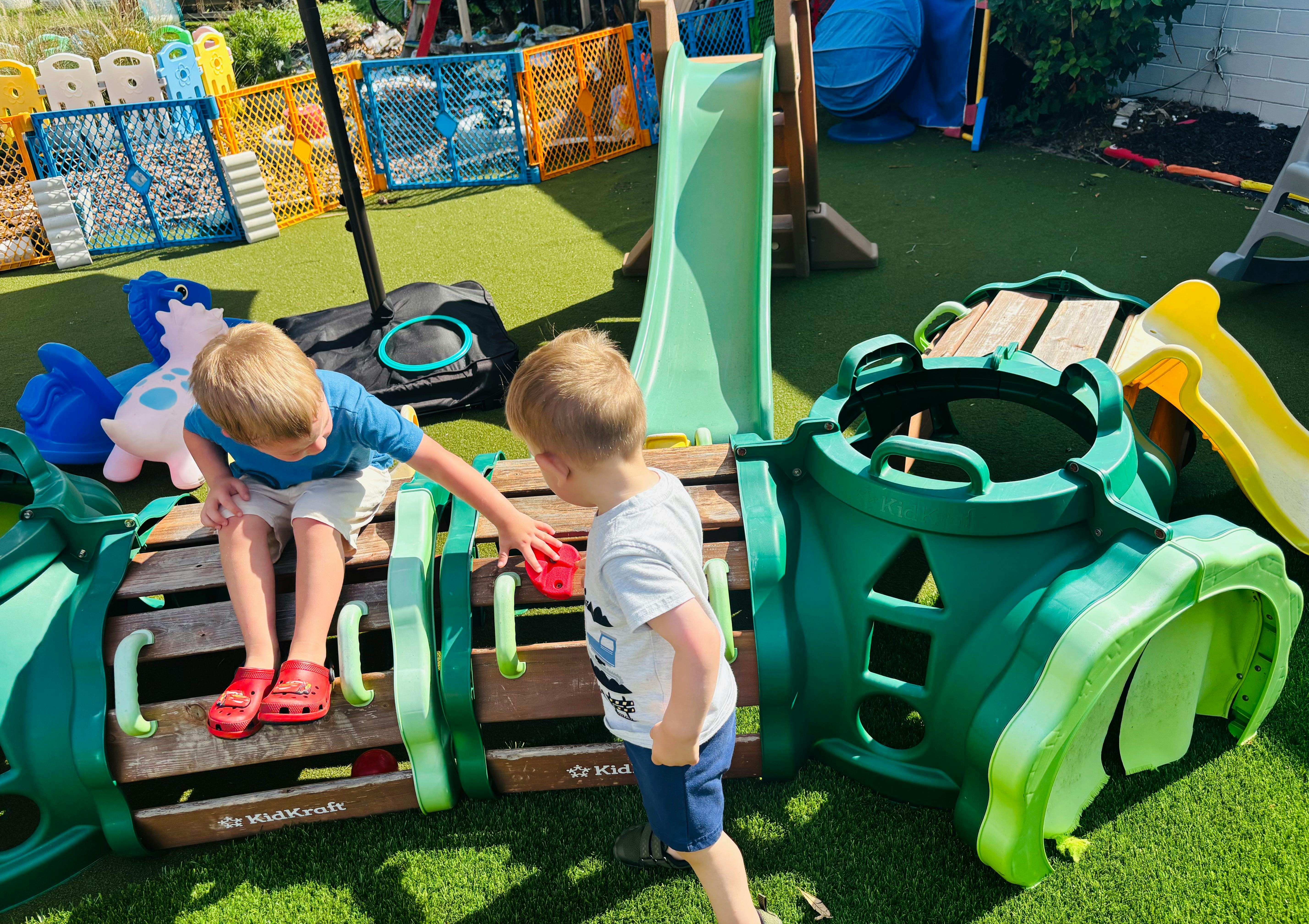 Two children playing on outdoor play equipment