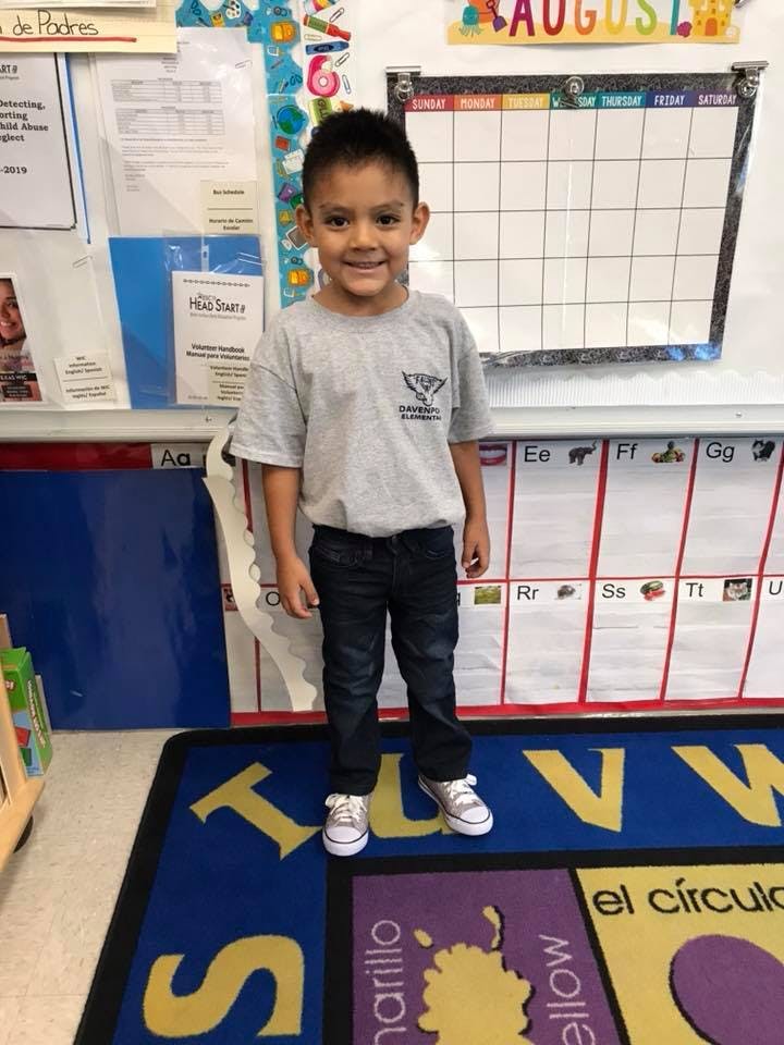 Child standing in a classroom