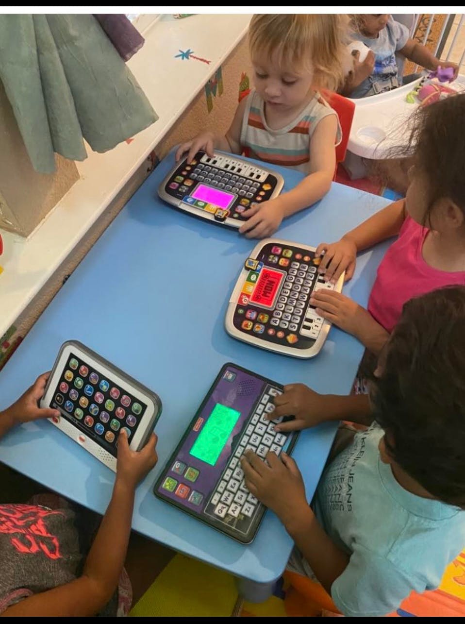 Children playing with electronic learning toys at a table