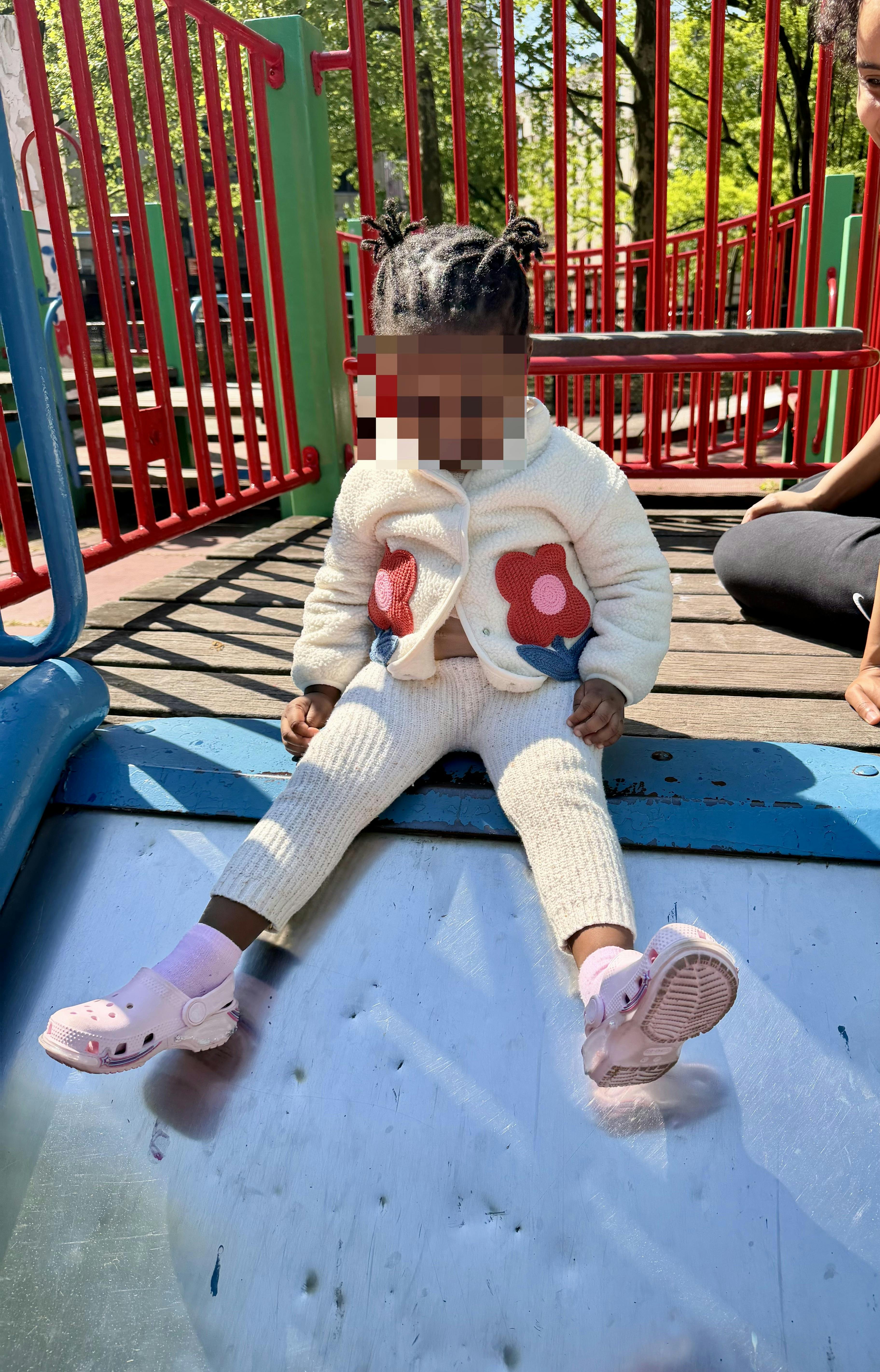 Child sitting on a slide at a playground