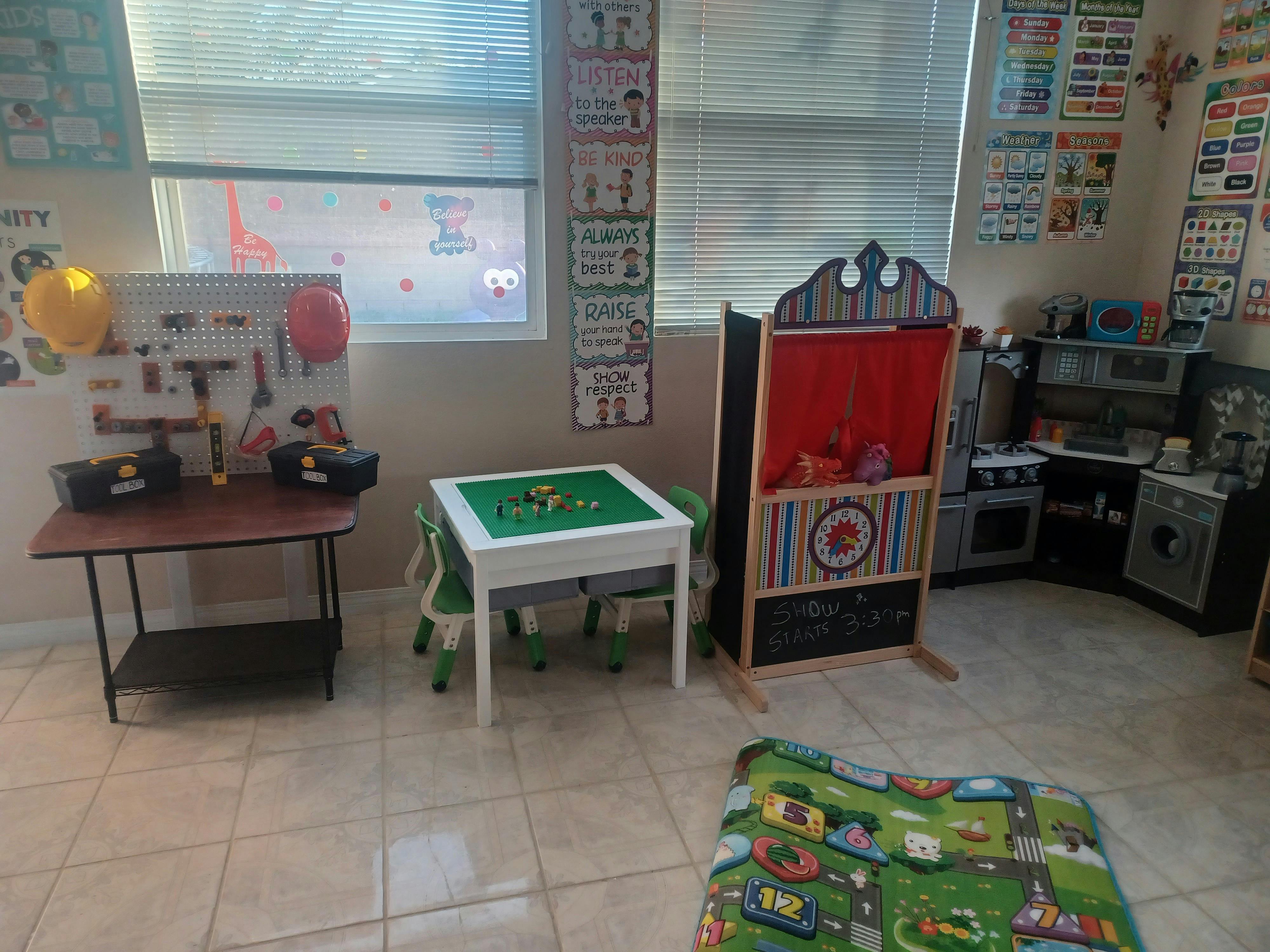 Playroom with a toy workbench, a small table with building blocks, and a puppet theater