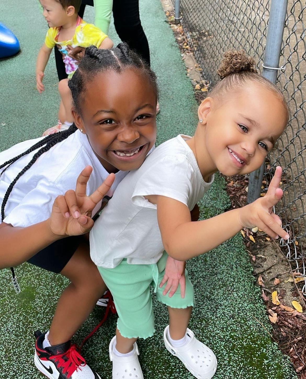 Two children smiling and making peace signs
