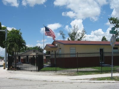 American flag flying above a building with a fence