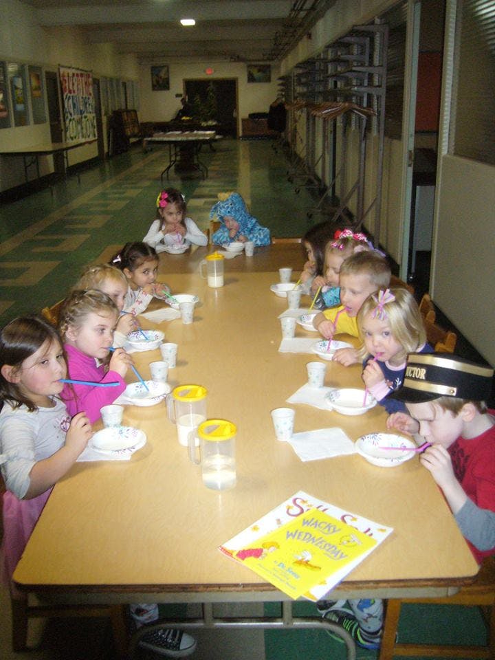 Children sitting at a long table eating from bowls
