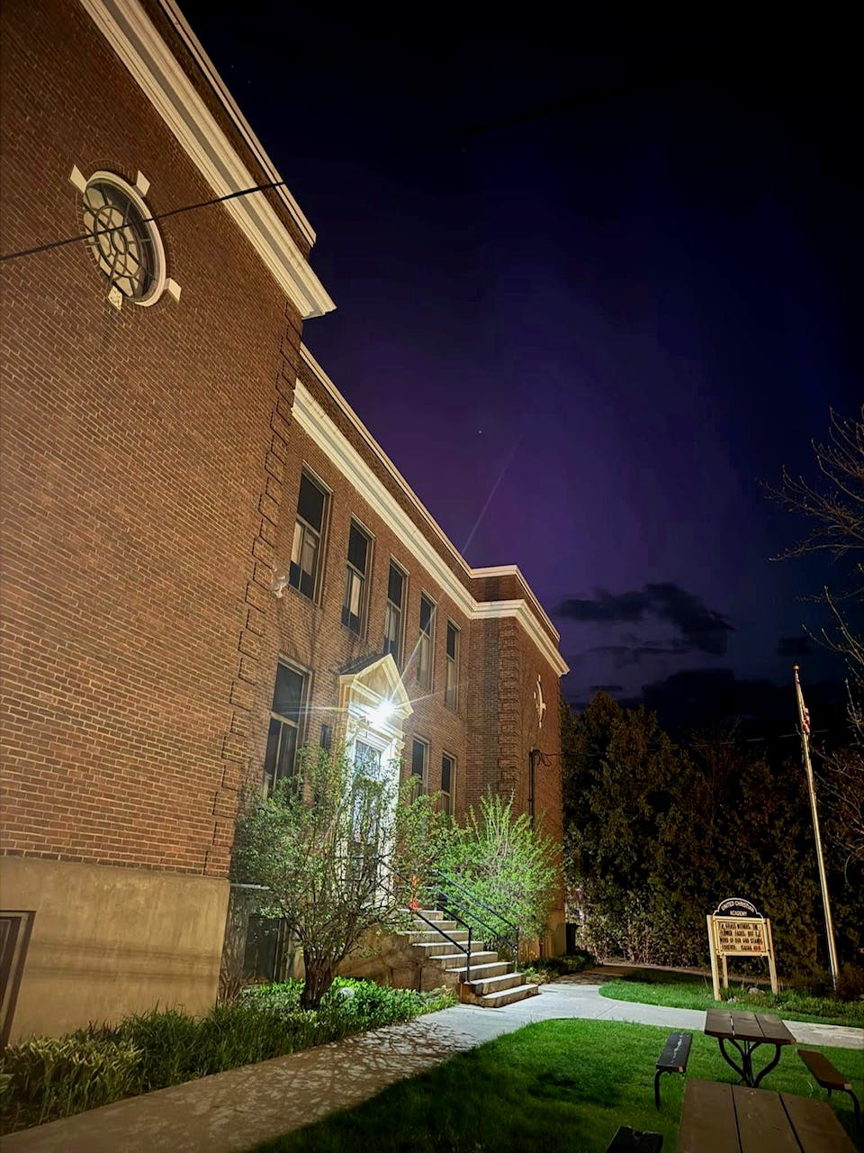 Brick building with steps leading to an entrance at night