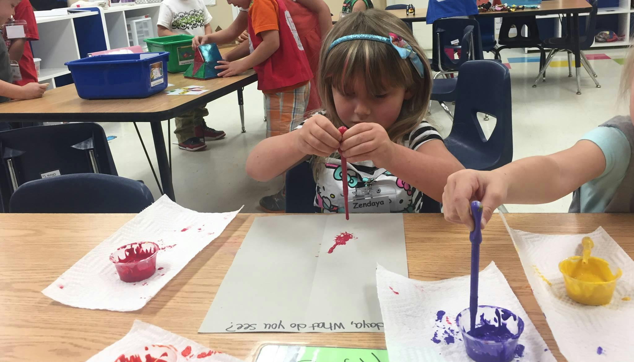 Child painting at a table in a classroom